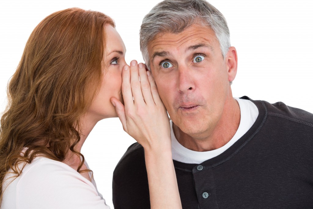 Woman telling secret to her partner